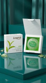 Longrich soap packaging on a reflective teal surface with green leaves.