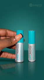 Two mouth freshener tubes with a hand holding one against a teal background