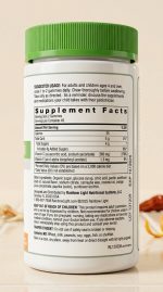 Supplement bottle with green cap and label on a beige background