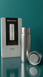 Silver thermos bottle with filter and packaging on a teal background