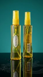 Two yellow spray bottles with labels on a reflective surface and dark background